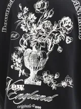 Remera negra de manga corta con cuello redondo y calce holgado, confeccionada en tejido de punto jersey de algodón. Presenta un pequeño estampado en el pecho.