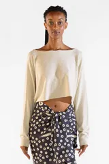 Sweater de escote bote confeccionado en tejido de punto con hilo metalizado, corte corto y mangas largas.