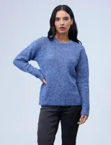 Buzo de lana melange color tostado, con cuello redondo y mangas largas.