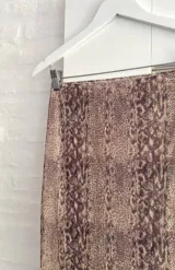 Pollera larga de microtul con estampado animal print de serpiente en tonos marrones, de corte ajustado y cintura elástica.