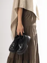 Mocasines negros de cuero con cordones y plataforma gruesa.