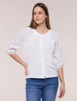 Blusa Liv Los Angeles de color blanco, confeccionada con torso de modal y mangas tres cuartos con detalles de bordado calado. Presenta cuello redondo con apertura central y cierre frontal de botones.