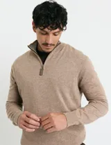 Remera de punto con medio cierre frontal, manga larga, cuello y puños en tejido canalé. Presenta un diseño con cierre metálico y detalle de puller en tono oliva.