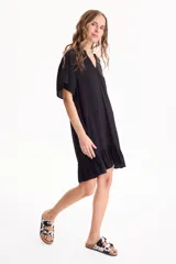 Vestido corto negro de viscosa, con escote en V, mangas cortas y volado en el ruedo.