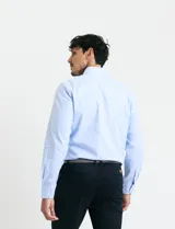 Camisa de vestir de manga larga en color celeste, con cuello clásico y cierre frontal de botones.