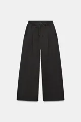 Pantalón de tiro alto con corte balloon, confeccionado en tejido de algodón. Presenta cintura elástica ajustable con cordones y bolsillos delanteros.
