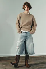 Jersey de punto liso con diseño oversize, cuello redondo y manga larga con puños acanalados.