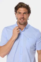 Camisa de manga corta a cuadros celestes y blancos, con bolsillo en el pecho y logo bordado.