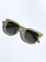 Lentes de sol marca Osten modelo Tokyo, con armazón de acetato en tono verde oliva mate y cristales oscuros polarizados. Presentan un diseño de marco completo con detalle de logo grabado en la patilla.