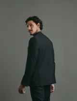 Traje de corte clásico compuesto por saco de dos botones con solapas tradicionales y pantalón de vestir a juego. Confeccionado en tejido liso de poliéster.