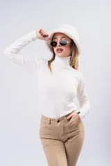 Polera de cuello alto y manga larga, confeccionada en tejido de punto con textura acanalada, de calce ajustado al cuerpo.