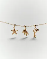 Dije colgante con forma de oso de peluche texturizado, color dorado, con detalle de cristal en una pata.