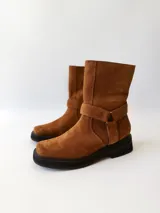 Bota corta de cuero color camel, con correa decorativa alrededor del tobillo y suela de goma negra.