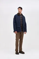Campera de gabardina color marrón con cuello de pana en tono oscuro. Presenta cierre frontal con botones a presión, bolsillos laterales con solapa y diseño de calce clásico.