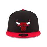 Gorra New Era modelo 9FIFTY de visera plana, color negro con visera y botón superior rojos. Presenta el logotipo bordado de los Chicago Bulls en el frente.