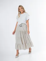 Remera blanca de tejido liviano con aplique de flor de crochet en el frente.