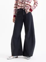 Jeans de corte wide leg y estilo balloon, color negro lavado. Presenta pinzas y recortes estratégicos en las piernas que aportan volumen y movimiento. De tiro medio, confeccionado en tejido de algodón liviano.