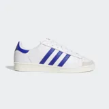 Championes Adidas Jabbar Lo de diseño clásico inspirado en los años 70. Presentan una parte superior de cuero blanco con las icónicas tres tiras laterales en azul, detalle en el talón a juego y puntera de gamuza gris claro. Cuentan con suela de goma y mediasuela de EVA para mayor comodidad.
