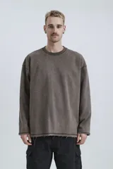 Buzo de cuello redondo con efecto de lavado desgastado, corte oversize y hombros caídos. Presenta costuras expuestas a contratono y detalles de roturas en el cuello, puños y ruedo.