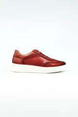 Champion de cuero color marrón con suela de goma blanca, diseño de cordones y costuras reforzadas.