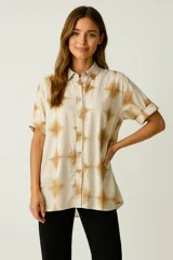 Camisa de corte holgado con estampado tie-dye en tonos beige y marrón. Presenta cuello clásico, cierre frontal con botones y mangas cortas con dobladillo.