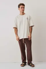Pantalón de tiro medio con cintura elástica y cordón ajustable, textura tejida, corte recto y silueta amplia.