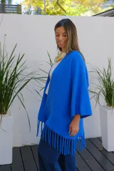 Saco abierto de punto color azul vibrante, con mangas tres cuartos y detalle de flecos largos en el ruedo.