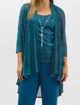 Conjunto de tres piezas compuesto por musculosa, cardigan y pantalón. La musculosa y el cardigan presentan un diseño plisado con hilos metalizados en tonos verdes y azules, creando un efecto tornasolado. El cardigan es de frente abierto con mangas 3/4 y corte fluido. El pantalón es de seda fría en color azul petróleo, con cintura elastizada. Incluye un collar removible.