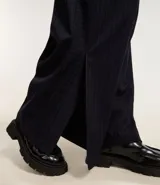 Pantalón pantalona de sastrería con rayas verticales, trabillas en la cintura y cierre con botón y cremallera. Confeccionado en poliéster, viscosa y elastano.