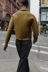 Chaqueta de punto de corte recto, color verde oliva, con cuello solapa, cierre frontal con cremallera y bolsillos delanteros de plastrón.