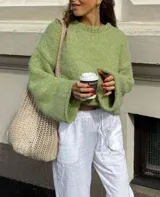 Sweater de punto color verde matcha, con diseño oversized, cuello redondo y mangas largas amplias.