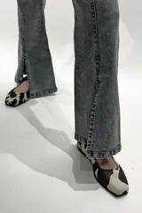 Pantalón jean gris de tiro medio alto, corte wide leg con tajo frontal.