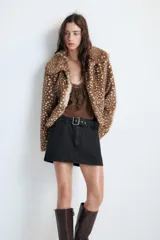 Cazadora de Zara con efecto pelo, diseño de cuello solapa y manga larga. Presenta un estampado animal print tipo cervatillo, bolsillos delanteros y cierre frontal con ganchos metálicos.