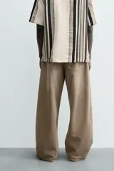 Jeans de hombre, corte balloon fit, tiro medio, confeccionados en denim rígido de algodón. Presentan un efecto lavado con un marcado degradado vertical, cinco bolsillos y cierre frontal con cremallera y botón.