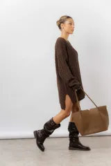 Cartera tipo tote de diseño amplio y estructurado, confeccionada en material sintético con textura graneada. Cuenta con doble asa larga para llevar al hombro y logo de la marca aplicado en el frente.