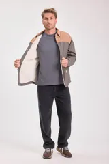 Cazadora acolchada con interior de piel sintética, color gris y beige, con cuello clásico, cierre con botones a presión y bolsillos laterales.