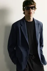 Blazer regular fit azul marino confeccionado en tejido con elasticidad, con cuello de solapas de muesca, cierre frontal con botones y bolsillos con solapa en la cadera.