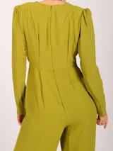 Mono largo de crepé color verde esmeralda, con escote en V cruzado, mangas largas abullonadas y pantalón palazzo. Cierre cruzado con dos botones dorados.