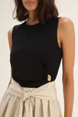 Musculosa negra sin mangas con detalle de broche dorado en el lateral.
