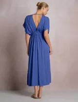 Vestido midi túnica color azul de la marca Elan, de corte holgado con escote en V profundo y mangas mariposa. Cuenta con una argolla central forrada que une el fruncido del busto y genera sutiles aberturas cut-out en la cintura. Presenta cintura elastizada y falda fluida con tajo lateral.