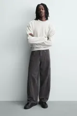 Zapatilla negra de cordones, con parte superior lisa y cordonera oculta. Posee suela con volumen a tono.