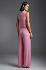 Chaleco rosa con escote cuadrado, corte al cuerpo y cierre frontal con botones.