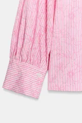 Camisa de manga larga con cuello solapa, cierre frontal con botones y puños abotonados. Presenta un diseño de rayas verticales combinadas con un estampado floral lineal superpuesto.