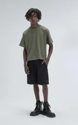 Remera de manga corta y cuello redondo, color verde militar, con calce boxy fit, caracterizada por ser ligeramente más corta y tener mangas amplias.