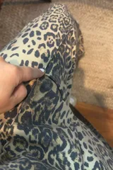 Pantalón de corte recto con estampado animal print en tonos beige y gris. Presenta cintura elástica y diseño holgado.