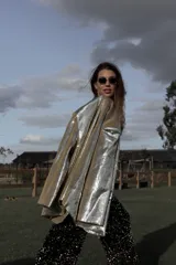 Blazer dorado con lentejuelas, solapas de muesca, corte recto y cierre frontal con un botón.