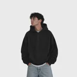Hoodie de corte oversize en color negro, confeccionado en algodón premium con textura suave. Presenta capucha amplia, bolsillo frontal tipo canguro y puños acanalados.
