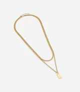 Collar doble dorado con cadena fina y dije rectangular.