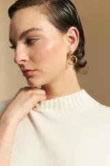 Polera de cuello alto confeccionada en tejido de punto negro, con diseño de textura acanalada en cuello, puños y ruedo, y trama vertical en mangas y espalda.