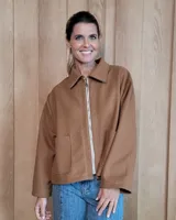 Chaqueta de textura bouclé en color bordó, con corte oversize, cuello camisero, cierre frontal y bolsillos laterales.